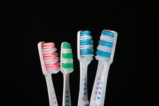 Six new tooth brushes on a black background.