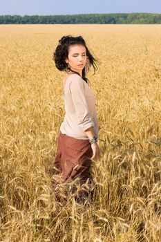 Young attractive girl standing in wheat field
