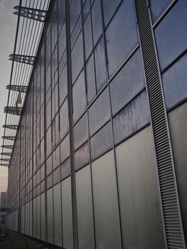 Unfinished modern building with outer wall made of glass and windows.