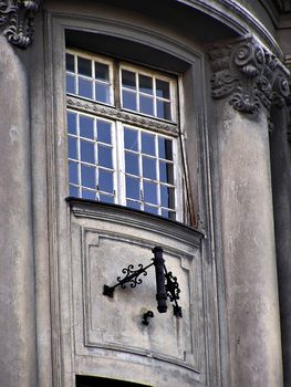 Ruined old gray building window with flag holder.