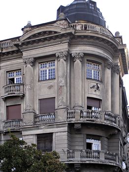 Ruined old city building with facade with many details.