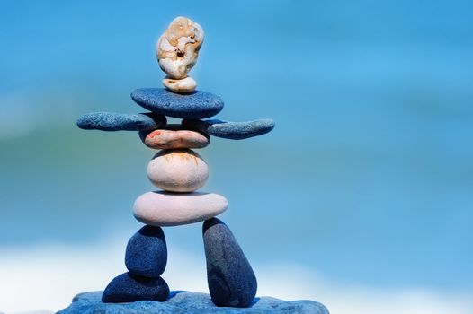 Figurine of pebbles on the against background the blue sky