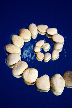 Spiral of gravel on the surface of the water