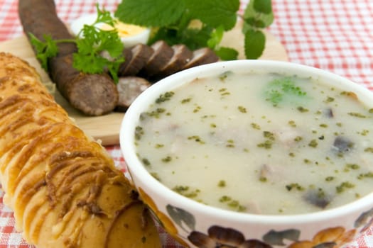 sour soup with egg, sausage and bread - traditional polish meal