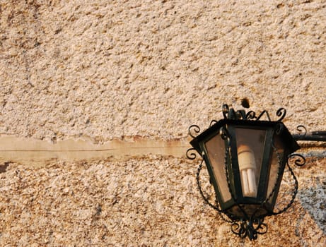 old vintage lantern against granite building wall