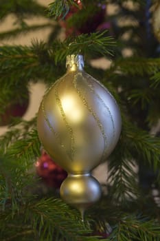 golden glass ball on green christmas tree