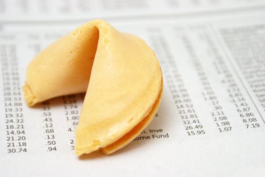 A fortune cookie on the stock investment section of a newspaper.