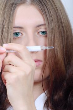 Portrait close up of the nice girl with the medical thermometer