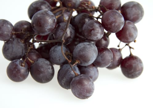Close up of black grape over a white background