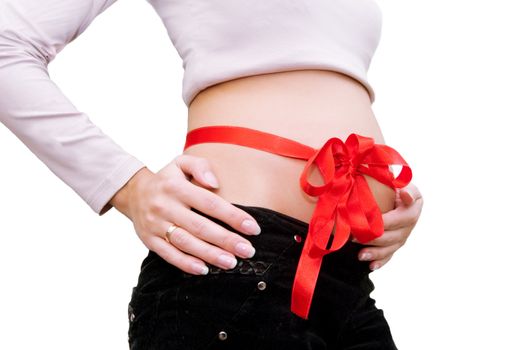 Pregnant woman's belly with red ribbon around her stomach