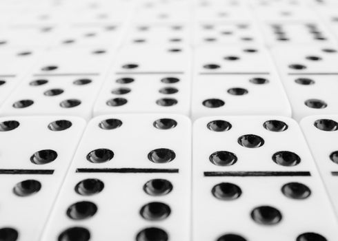 Surface covered with gray dominoes bones close up