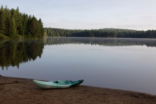 A kayak sitting on the shore of Pog Lake, Algonquin Provincial Park, Ontario, Canada.