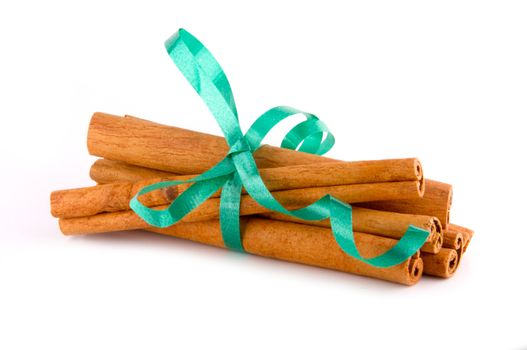 Cinnamon sticks bundled together with festive green ribbon