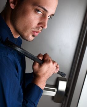 Burglar breaking into a building using crowbar