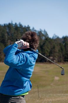 Male golfer looking up in his finish with unfocused background