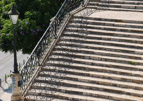 beautiful close up of a typical stairway made of calcada pavement with a gorgeous retro lamp post