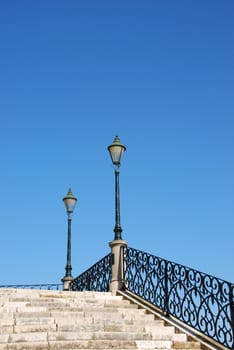 beautiful close up of a typical stairway made of calcada pavement with a gorgeous retro lamp post
