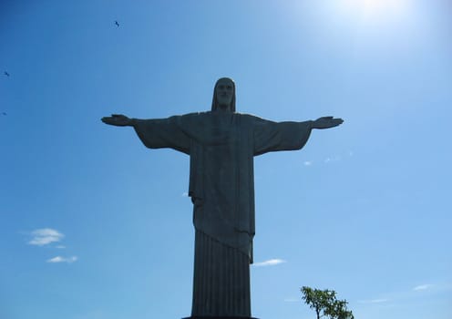 A view of the Statue of Christ, Corcovado, in Rio de Janeiro, Brazil with the sun shining from the right.
