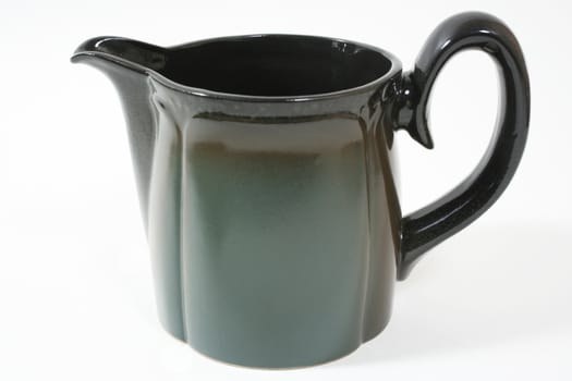 Large green ceramic milk jug, close-up.