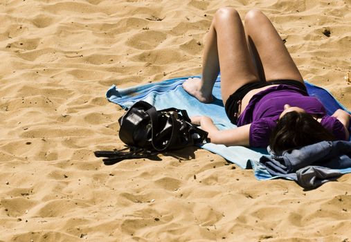 Woman sunbathing on a beach in spring in Malta