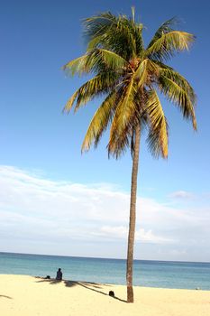 Lonely girl sitting on sand near the ocean