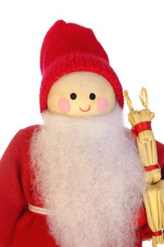 A wooden Father Christmas doll, holding a straw baby reindeer, isolated on a white background.