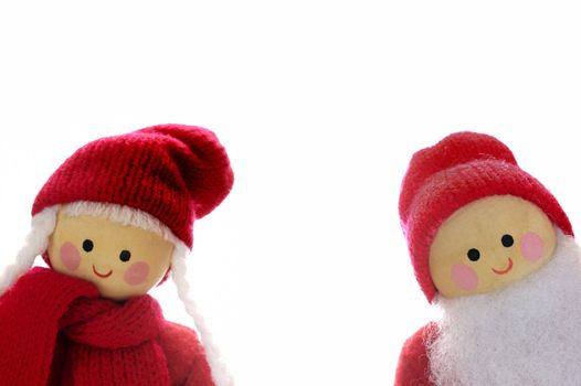 Two wooden dolls, Father and Mother Christmas, peeping into the frame, isolated on a white background. Space for text.