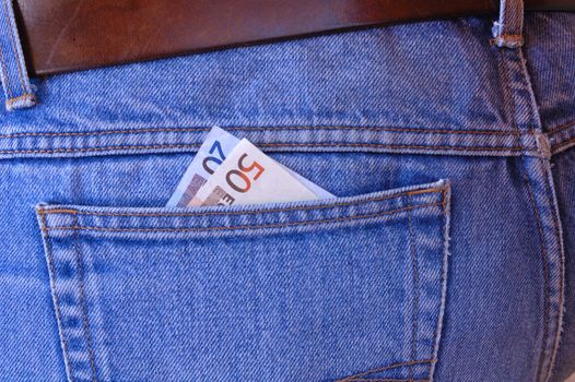Two Euro notes poke out of the rear pocket of a traveller's jeans. Tempting to a pickpocket.