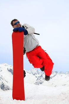 Happy man jump near snowboard over sky