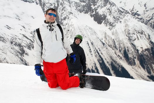 Two smiling man with snowboards on mountain