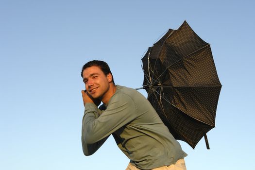 young man with umbrella at sunset light