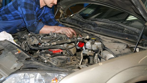 mechanic working with engine in the car service