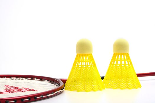 Yellow shuttlecocks for badminton and a racket.