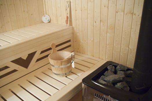 sauna with bucket and fireplace made of glowing stones