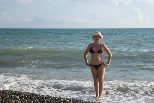 young pretty woman walks on sea beach