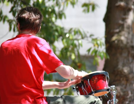 Jazz drummer performing outdoors in concert.