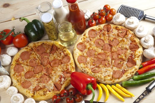 A couple of delicious pizzas, with raw tomatoes, green peppers and salami