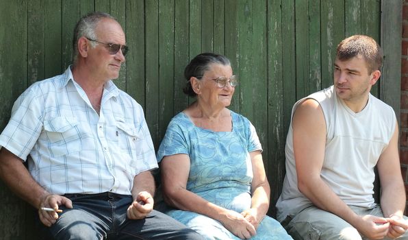 The son and grandson came to visit her grandmother, and sat on a bench near the courtyard