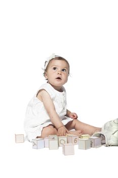 Girl playing with alphabet blocks isolated on a white background