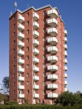 A light red apartment complex against a blue sky