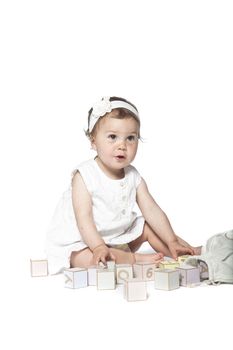 Girl playing with alphabet blocks isolated on a white background