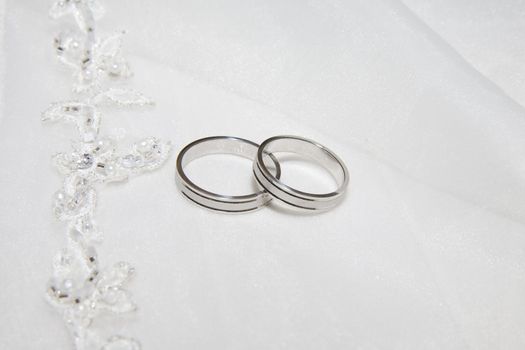 two wedding rings photo taken on some satin fabric