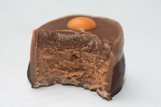 Half a milk choclate, luxury Belgium praline with orange decoration