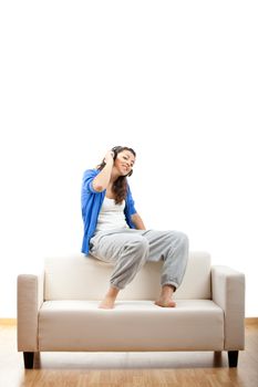 Portrait of a girl seated on the couch and making a phone call