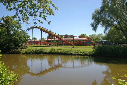 An attraction in a theme park with it's reflection in a lake.