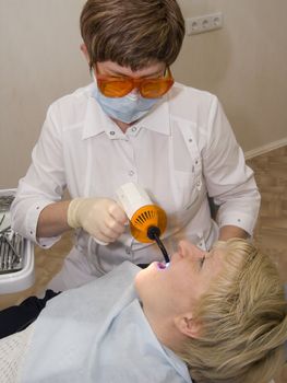  The stomatologist carries out photopolymerization of the sealed up tooth
