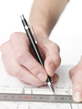 Male architect working on a bluprint, close up on hand and bluprint.