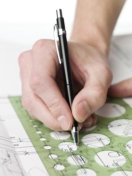 Male architect working on a bluprint, close up on hand and bluprint.