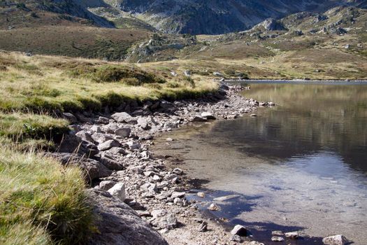 Autumn day in mountain. Small lake in Pyrenees, Andorra