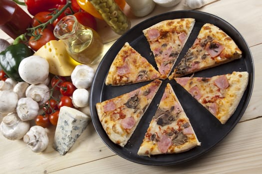 A couple of delicious pizzas, with raw tomatoes, green peppers and mushrooms